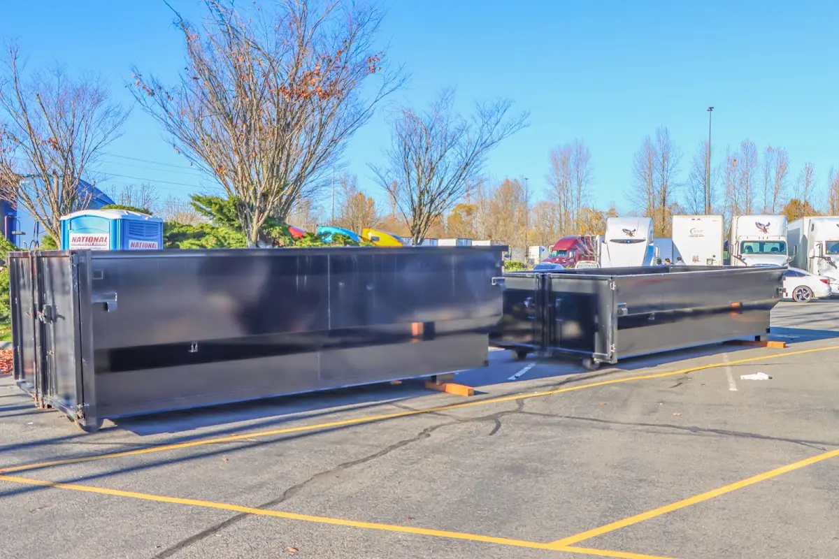 Professional dumpster rental service with roll-off container on residential driveway in Progress Village
